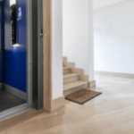 l'interno di un condominio si vede un ascensore e delle scale un vaso con una pianta